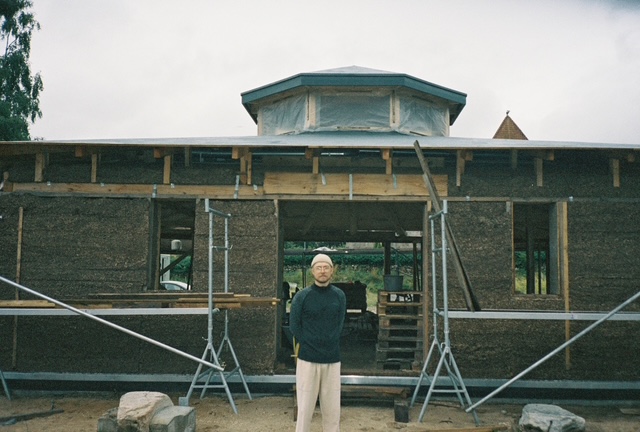 In front of a hempcrete house under construction